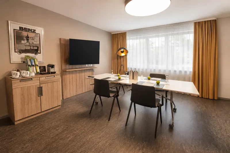 Boardroom in Mannheim: Meetingraum mit Konferenztisch, Bildschirm und Kaffeestation